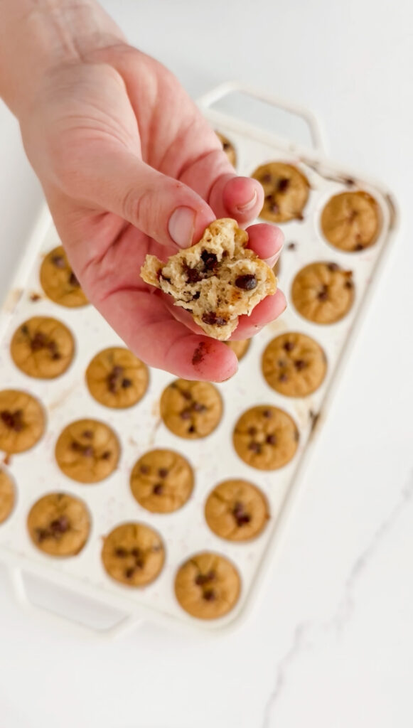 Banana bread mini muffins in a pan with hand